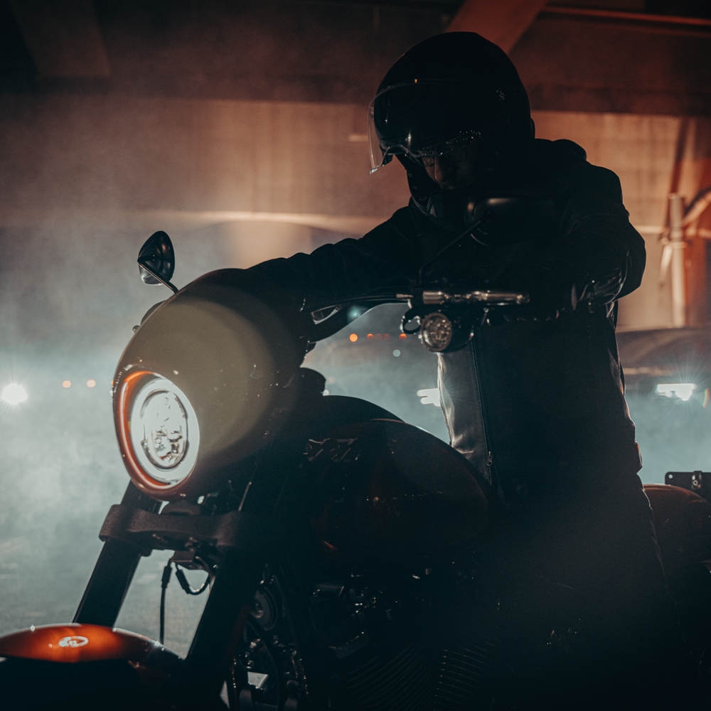 Male on a Harley-Davidson Low Rider S at night time.